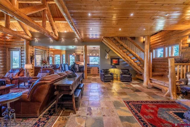 a living room with furniture a large window and wooden floor