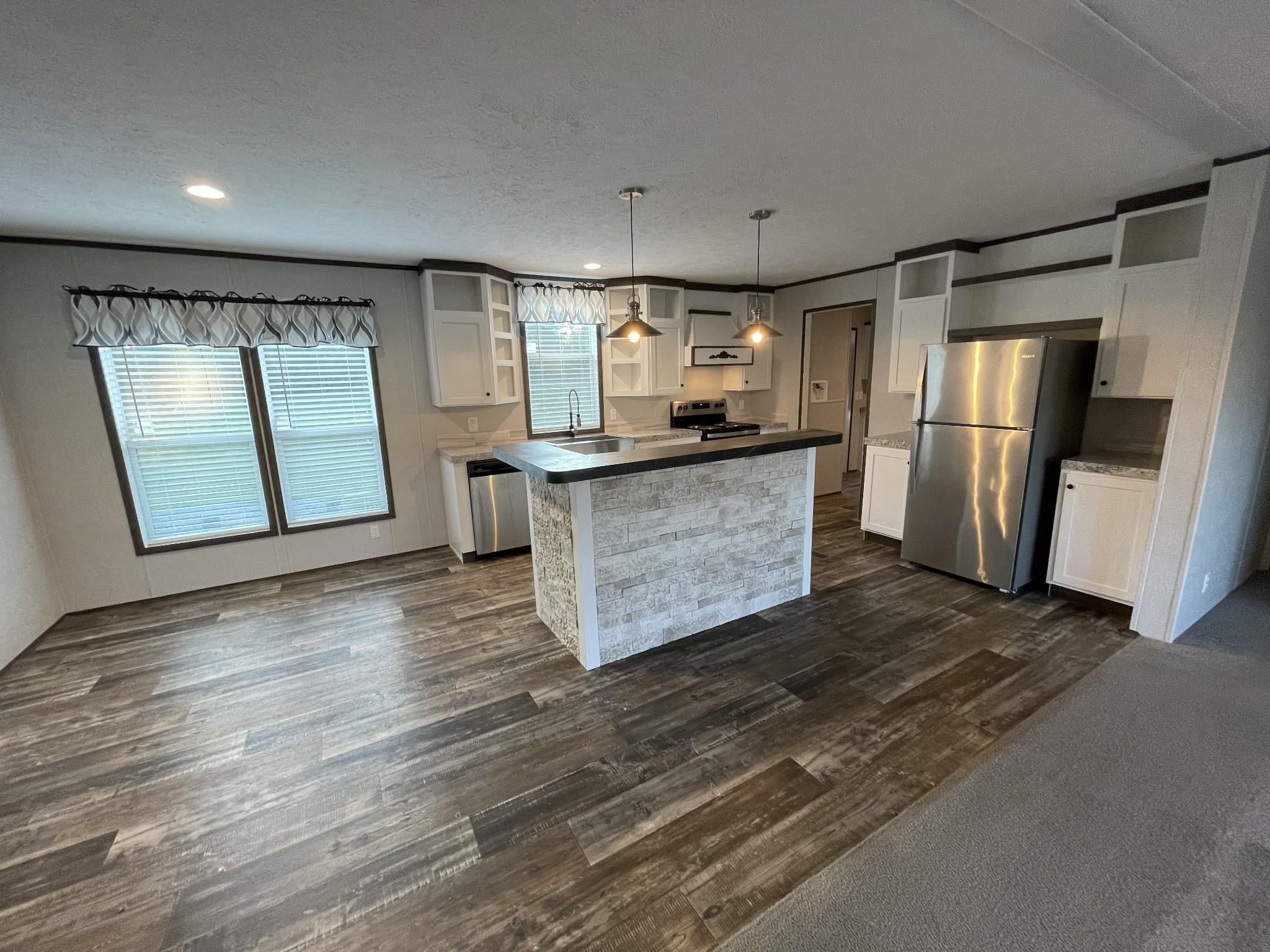 826 Pointe Lane Lafayette, TN 37083 - Photo 5 of 21 a kitchen with stainless steel appliances granite countertop a refrigerator a stove a sink and a microwave oven with wooden floor
