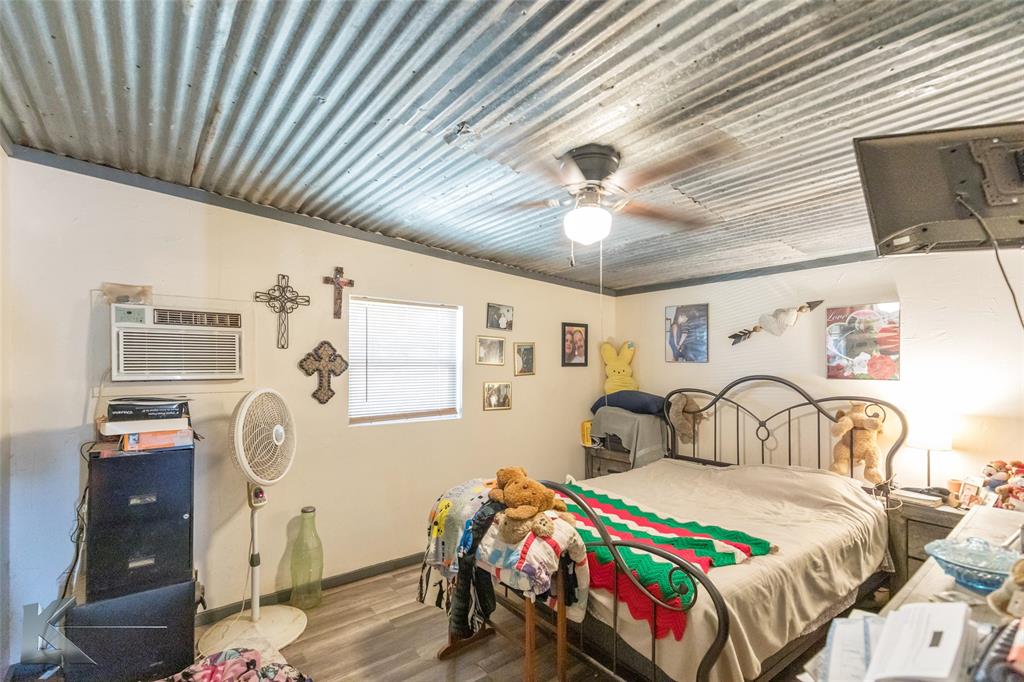 576 McCartney Lane Tye, TX 79563 - Photo 12 of 38 a bedroom with a bed and a chandelier