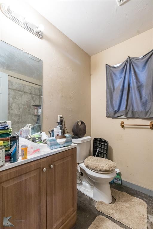 576 McCartney Lane Tye, TX 79563 - Photo 33 of 38 a bathroom with a toilet a sink and mirror