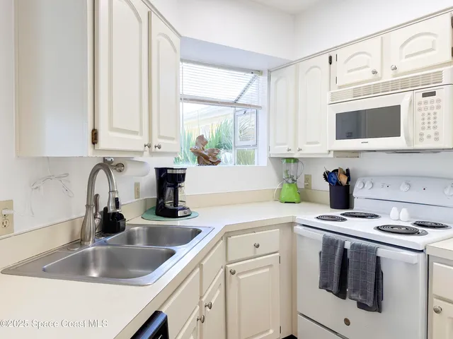 a kitchen with white cabinets and white appliances