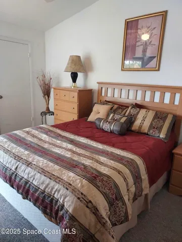 a bedroom with a bed and a painting on the wall