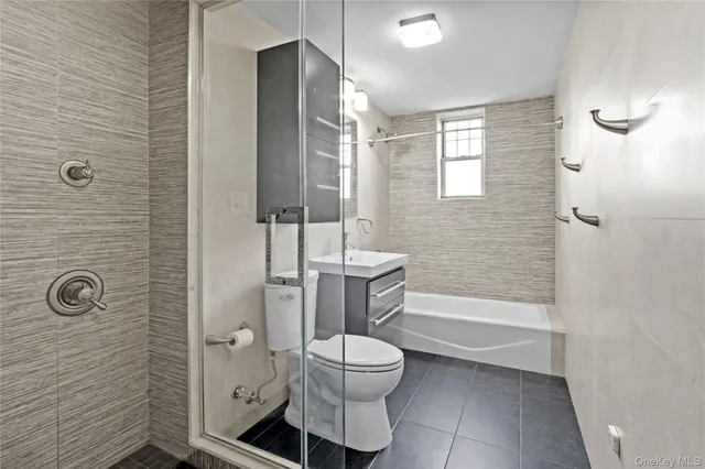 a bathroom with a toilet a sink a shower and mirror