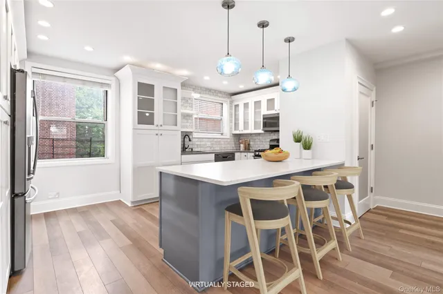a kitchen with stainless steel appliances granite countertop a kitchen island hardwood floor and a sink