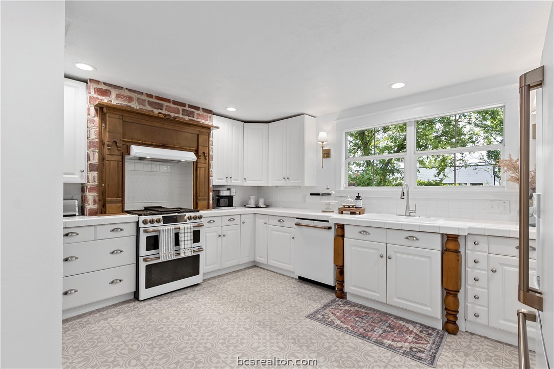 705 South Bryan Avenue Bryan, TX 77803 - Photo 23 of 47 a kitchen with white cabinets and white appliances