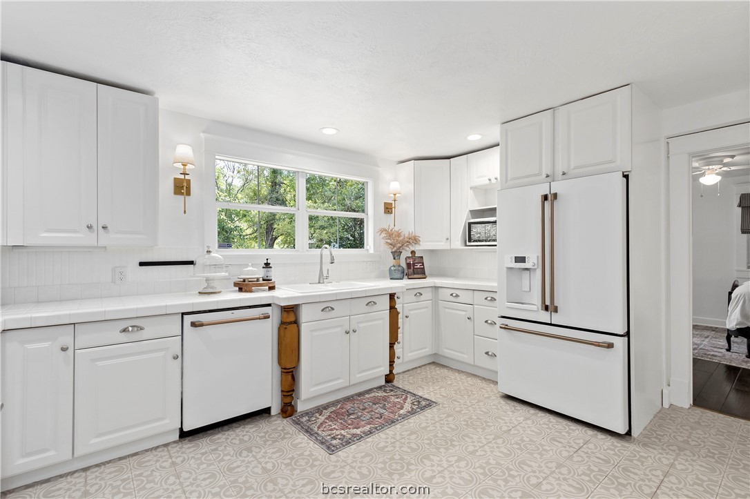 705 South Bryan Avenue Bryan, TX 77803 - Photo 24 of 47 a kitchen with white cabinets and white appliances