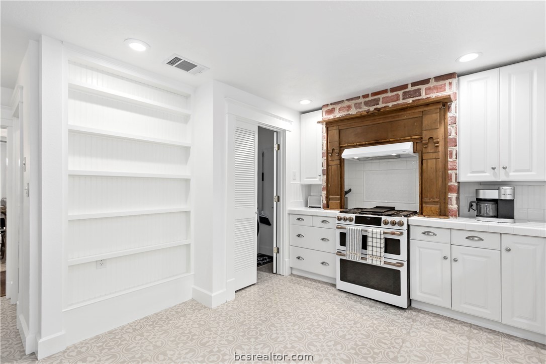 705 South Bryan Avenue Bryan, TX 77803 - Photo 25 of 47 a kitchen with white cabinets and white appliances