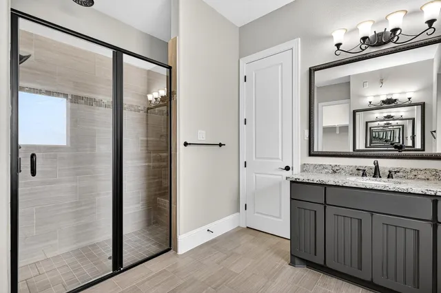 a bathroom with a double vanity sink mirror and shower