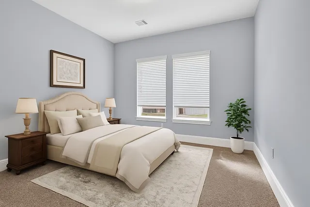 a bedroom with a large bed and a potted plant