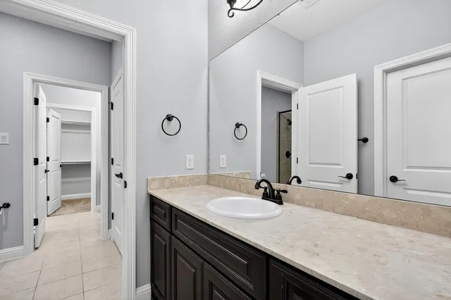 a bathroom with a granite countertop sink and a mirror
