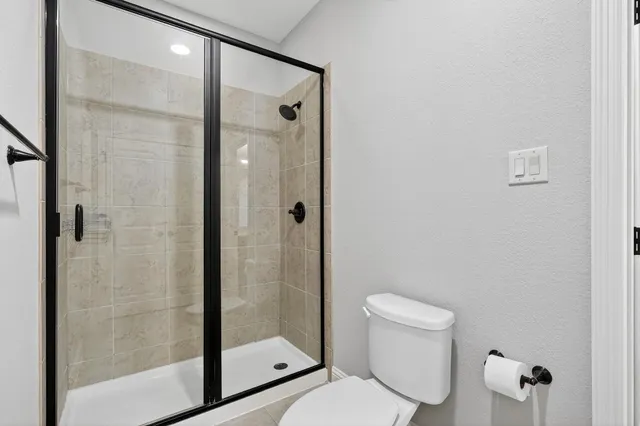 a bathroom with a shower a toilet and a sink