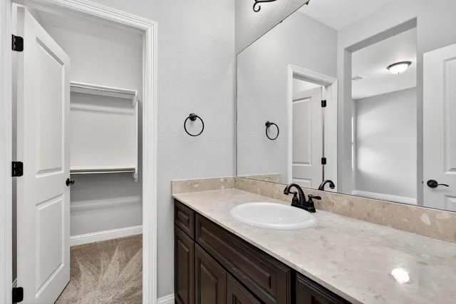 a bathroom with a granite countertop sink and a mirror