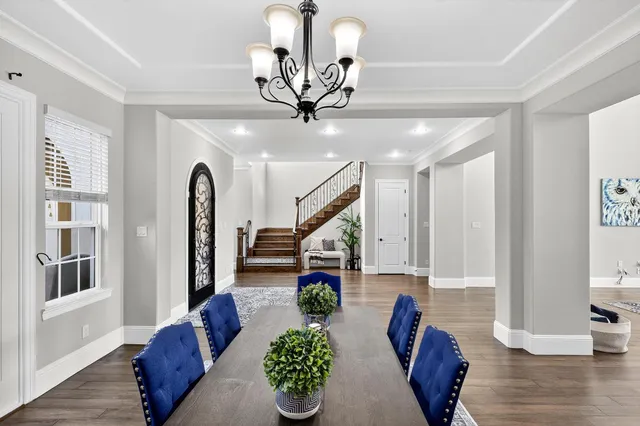 a living room with couches painting on the wall and a potted plant