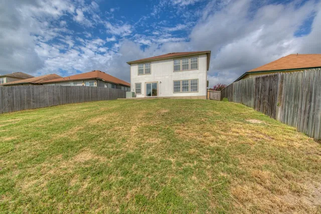 a view of an house with backyard and a tree