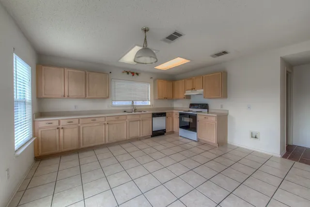 a kitchen with a sink window and cabinets