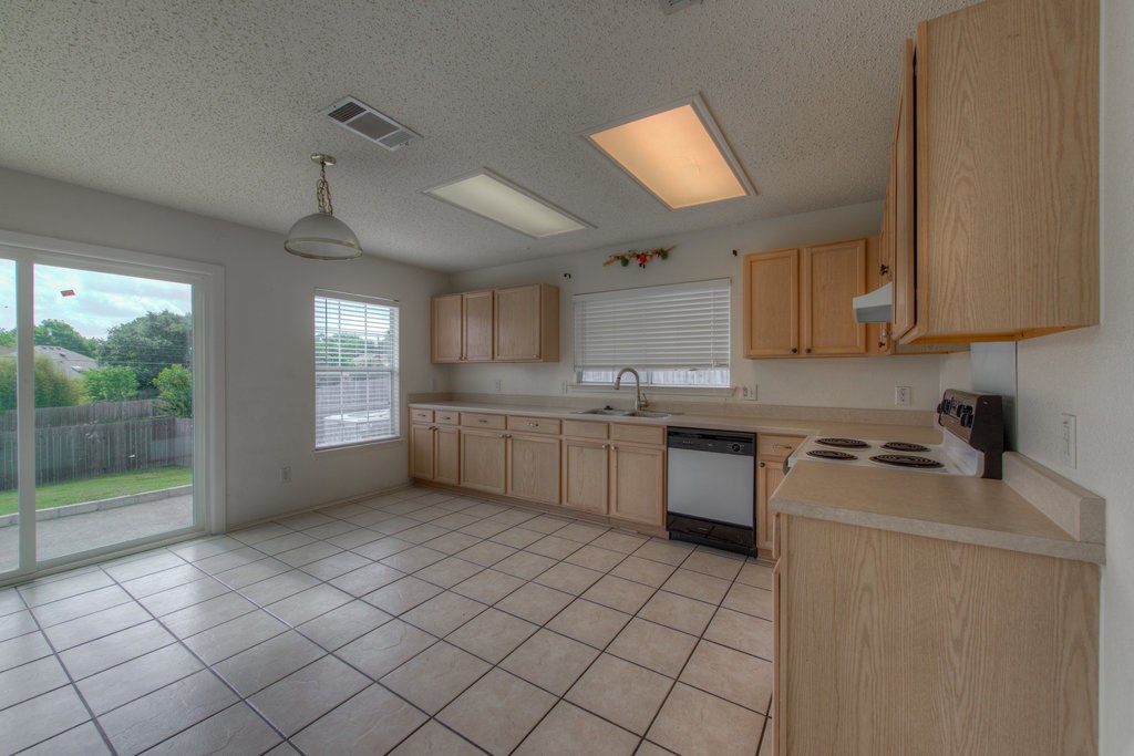 2623 Andres Way Round Rock, TX 78664 - Photo 7 of 15 a kitchen with a sink a stove cabinets and a window