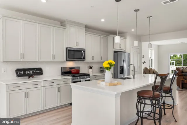 a kitchen with a sink a stove and white cabinets