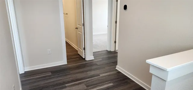 a view of hallway with wooden floor