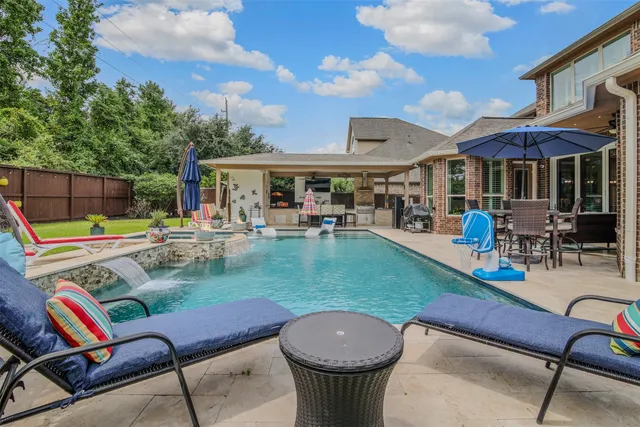 swimming pool view with a seating space and a garden