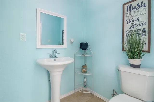 a bathroom with a sink a toilet and a mirror