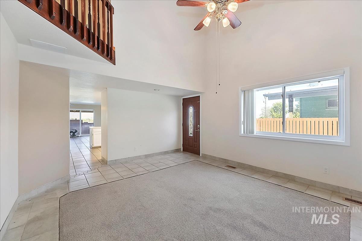 2804 West Sunrise Rim Road Boise, ID 83705 - Photo 6 of 50 Spacious living area featuring high vaulted ceilings, light-colored carpeting, and a decorative ceiling fan