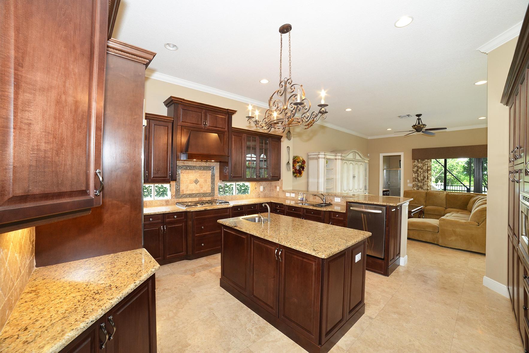 9812 Equus Circle Boynton Beach, FL 33472 - Photo 15 of 39 a kitchen with kitchen island granite countertop a sink stove and refrigerator