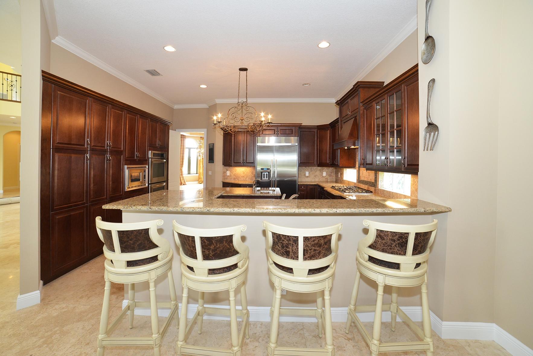 9812 Equus Circle Boynton Beach, FL 33472 - Photo 17 of 39 a kitchen with a dining table chairs cabinets and stainless steel appliances