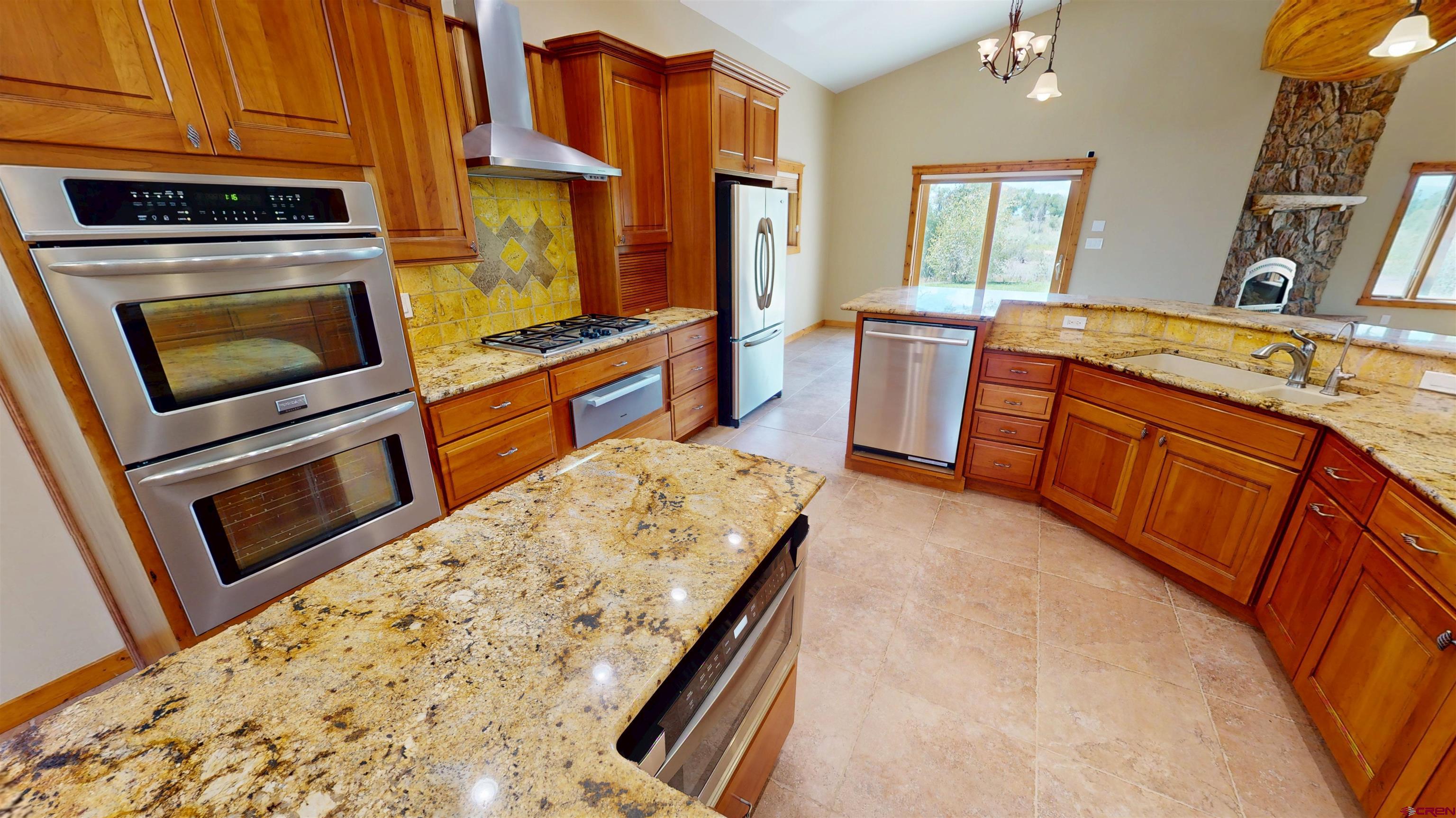 7857 Oxbow Loop Alamosa, CO 81101 - Photo 11 of 24 a kitchen with stainless steel appliances granite countertop a stove a sink and a refrigerator
