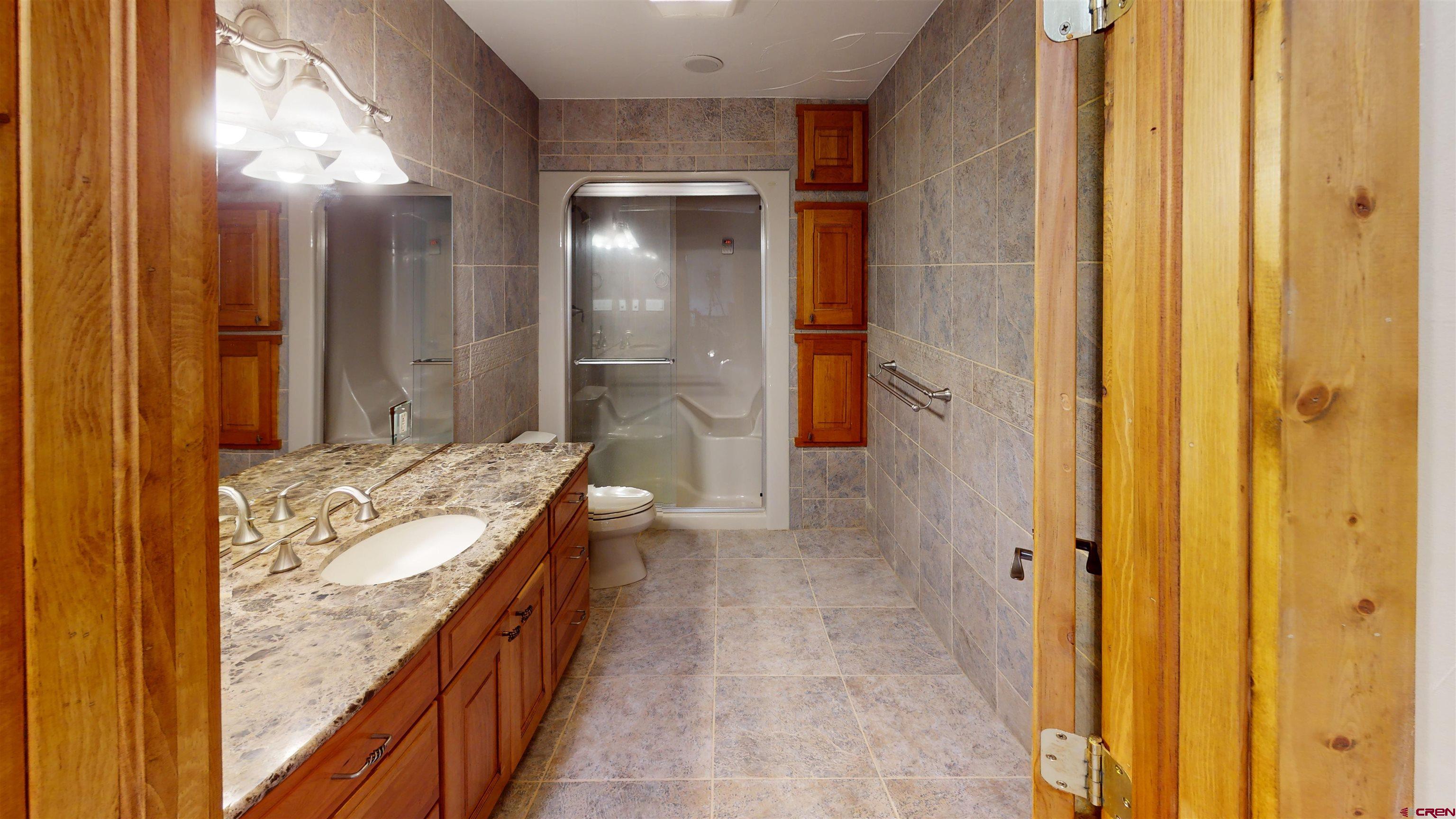 7857 Oxbow Loop Alamosa, CO 81101 - Photo 16 of 24 a bathroom with a granite countertop sink and a mirror