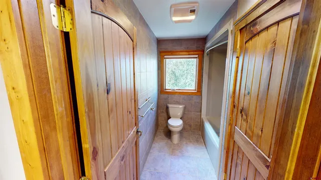 an empty room with a ceiling fan and a window