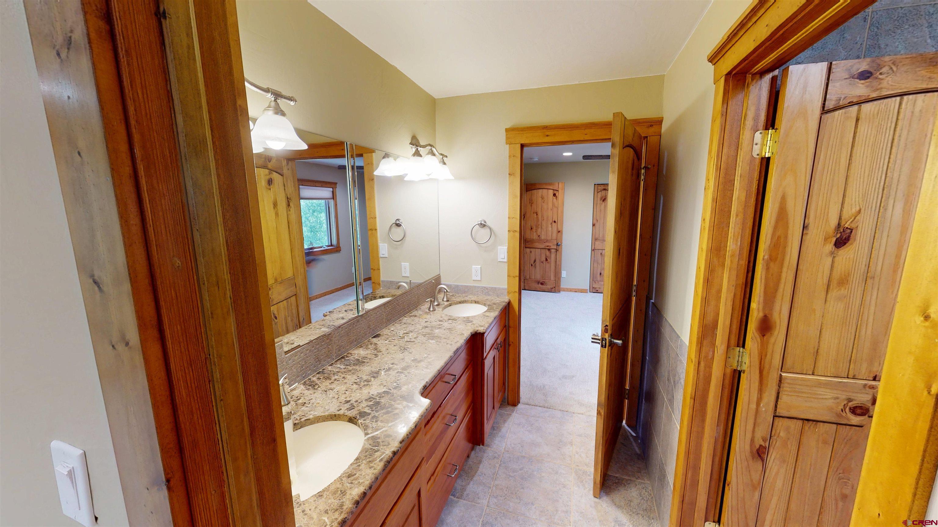 7857 Oxbow Loop Alamosa, CO 81101 - Photo 21 of 24 a bathroom with a granite countertop sink and a mirror