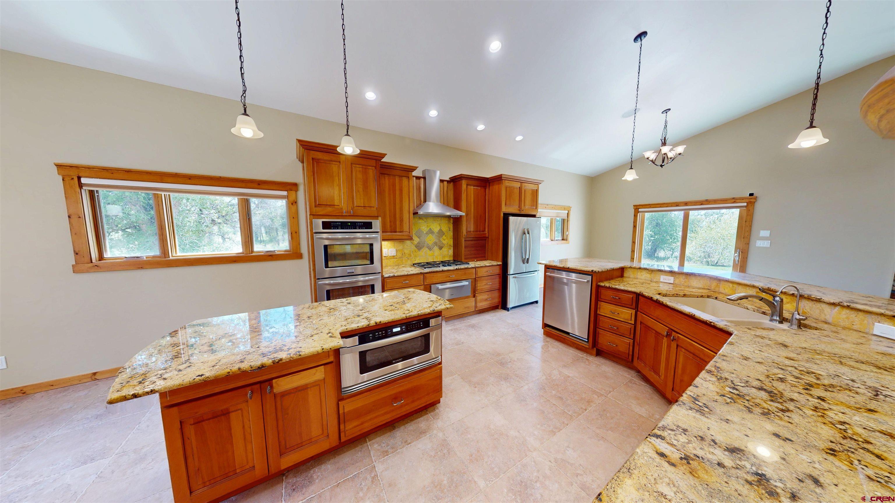 7857 Oxbow Loop Alamosa, CO 81101 - Photo 10 of 24 a large kitchen with stainless steel appliances granite countertop a stove and large refrigerator