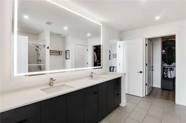 a bathroom with a double vanity sink shower and a mirror