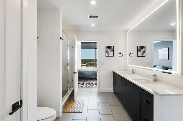a spacious bathroom with a toilet a sink and mirror