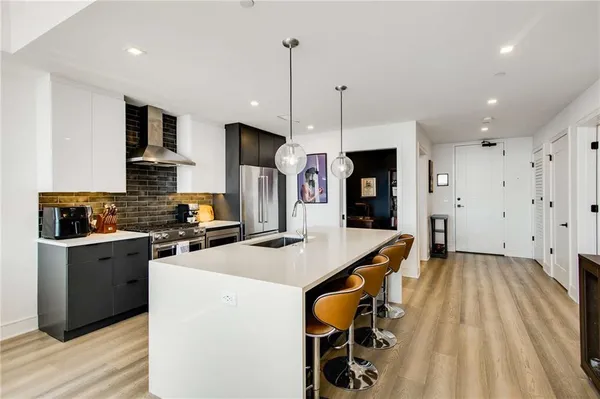 a kitchen that has a lot of cabinets a sink and a refrigerator