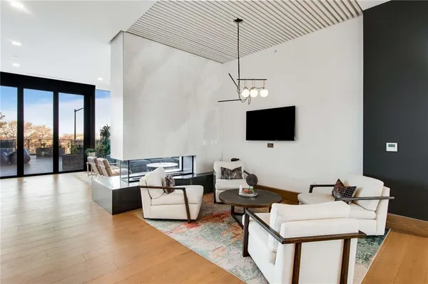 a living room with furniture pool table flat screen tv and a wooden floor