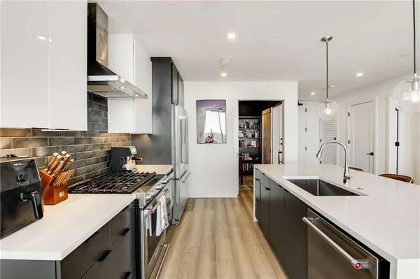 a kitchen with stainless steel appliances a sink stove and refrigerator