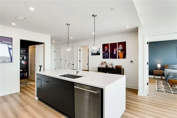 a kitchen with a sink a stove a refrigerator and island with wooden floor