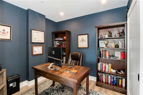 a view of a workspace with furniture and bookshelf