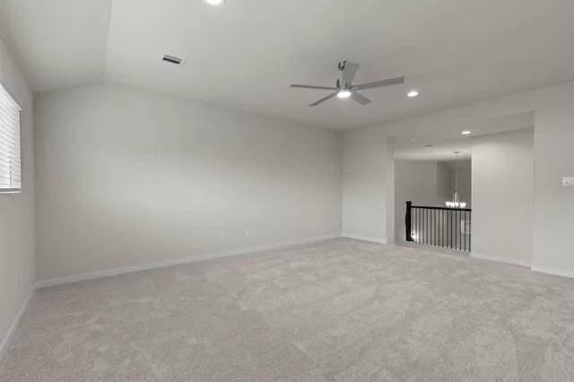 an empty room with a ceiling fan and window