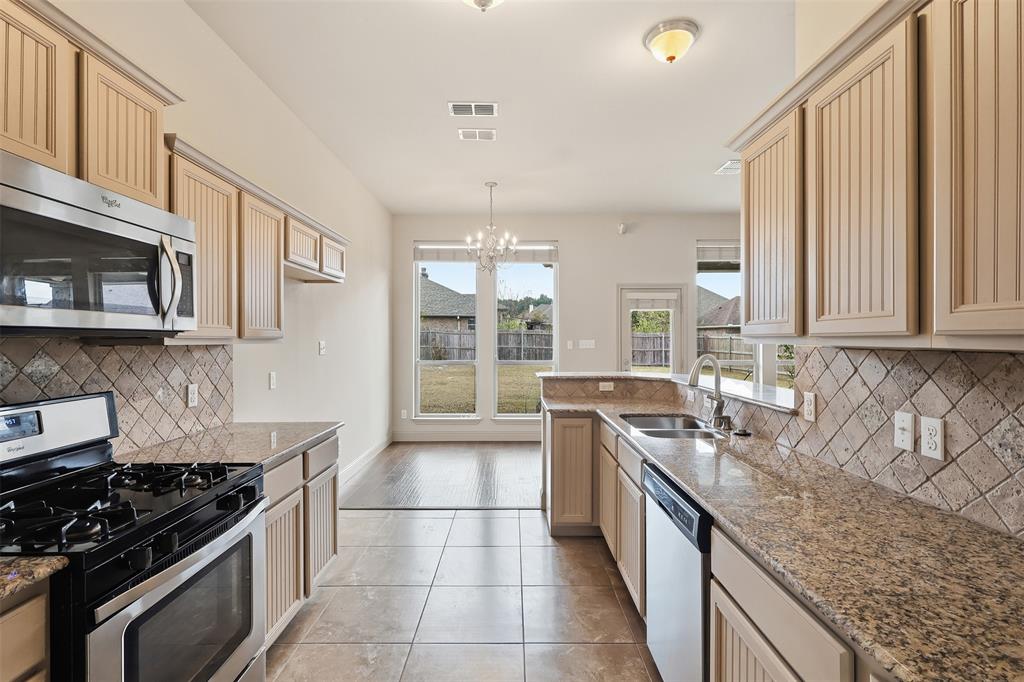 2512 Guinn Farms Road Tyler, TX 75707 - Photo 20 of 29 a kitchen with stainless steel appliances granite countertop a stove a sink and a microwave