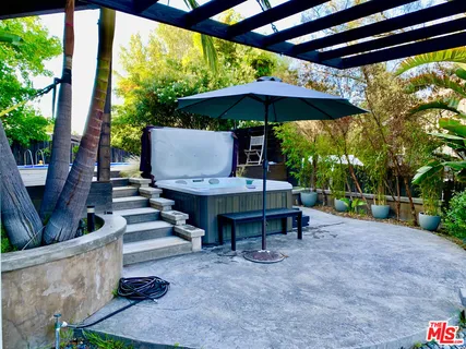 a view of patio with table and chairs under an umbrella