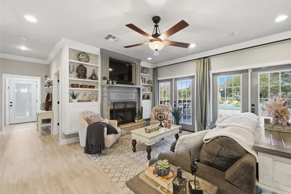 a living room with furniture kitchen view and a chandelier