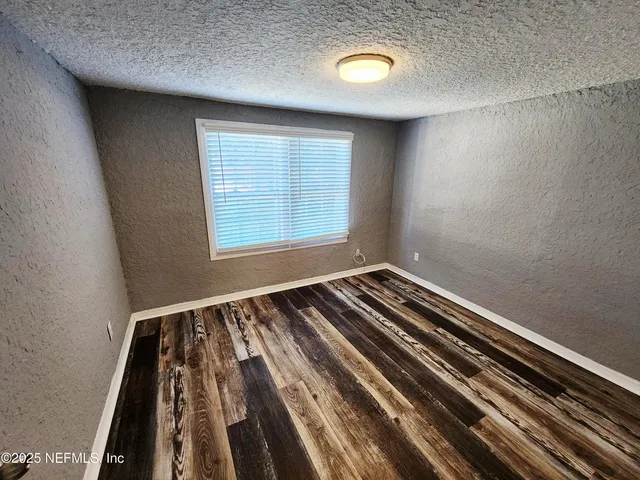 a view of a room with wooden floor