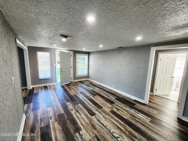 a view of a room with wooden floor
