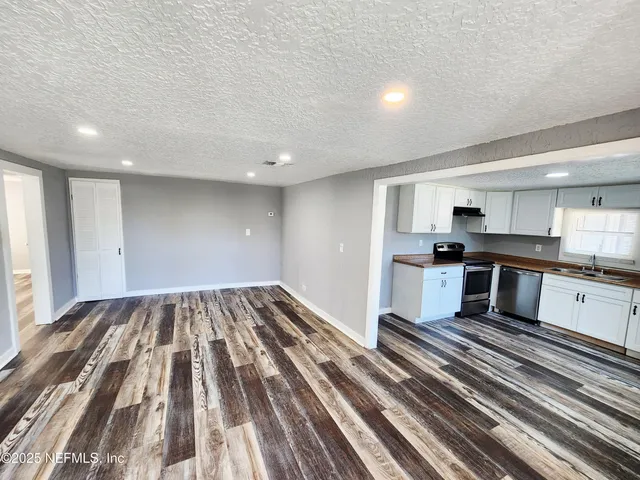 a view of kitchen with wooden floor and electronic appliances