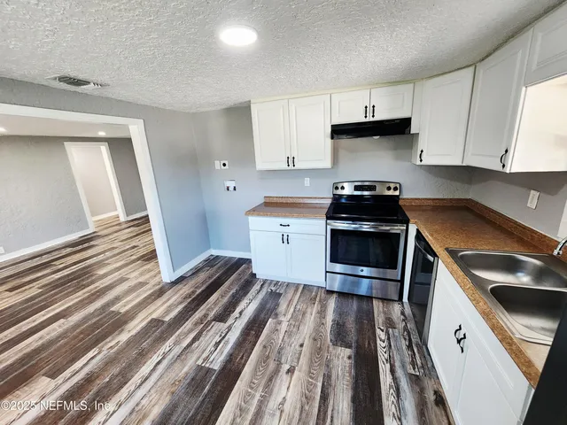 a kitchen with wooden cabinets and a stove top oven