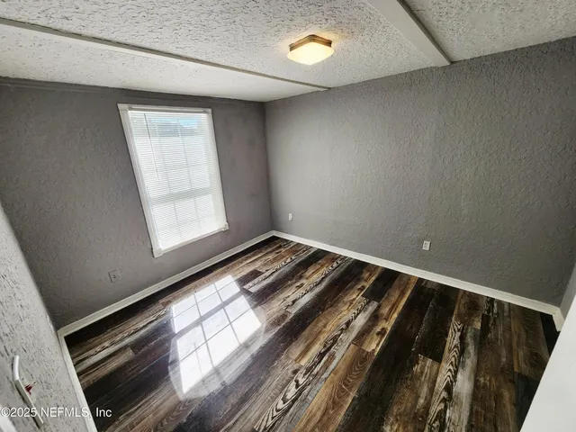 a view of an empty room and wooden floor