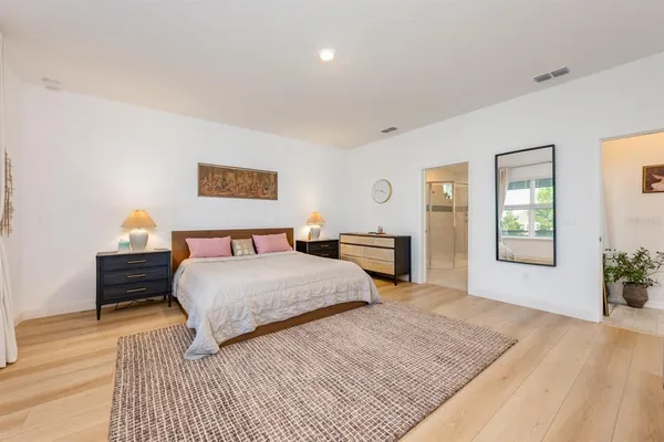 a bedroom with a bed and wooden floor