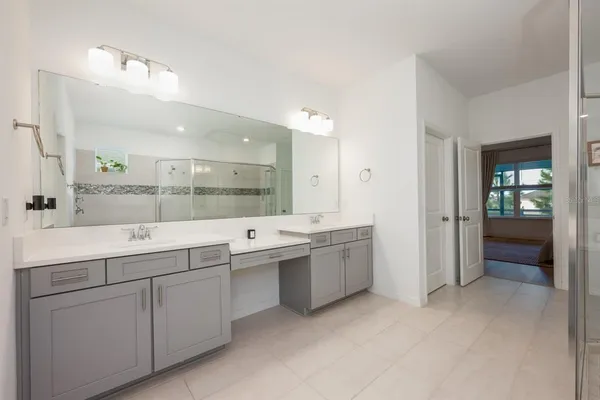a large bathroom with a large mirror vanity and shower